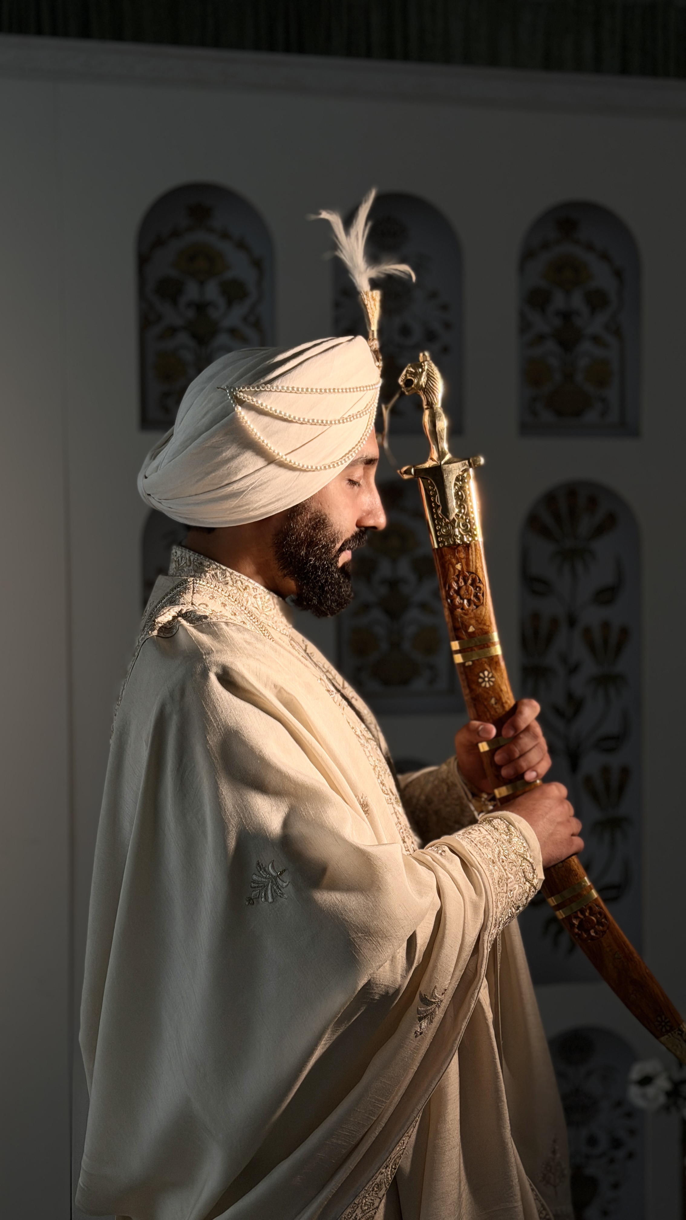 Groom wearing an elegantly tied maroon and gold wedding turban