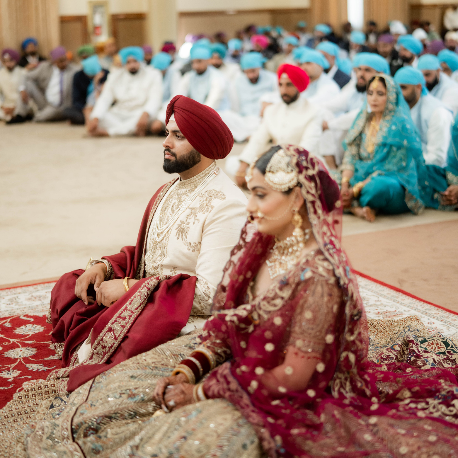 Hands crisply pleating a maroon and gold turban